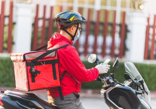 young-man-working-food-delivery-service-checking-with-road-motorcycle-city_43157-1931